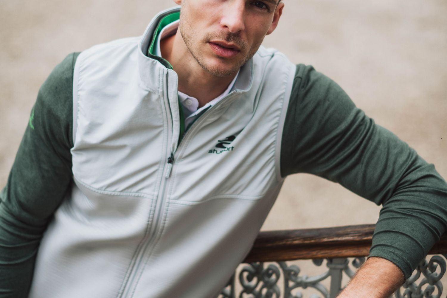 A golfer in a grey Stuburt gilet layered over a green mid layer