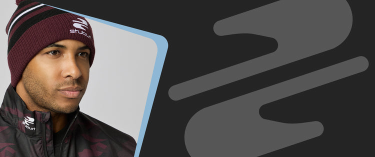 Man wearing a maroon beanie and jacket with a brand logo, against a dark background with abstract shapes.