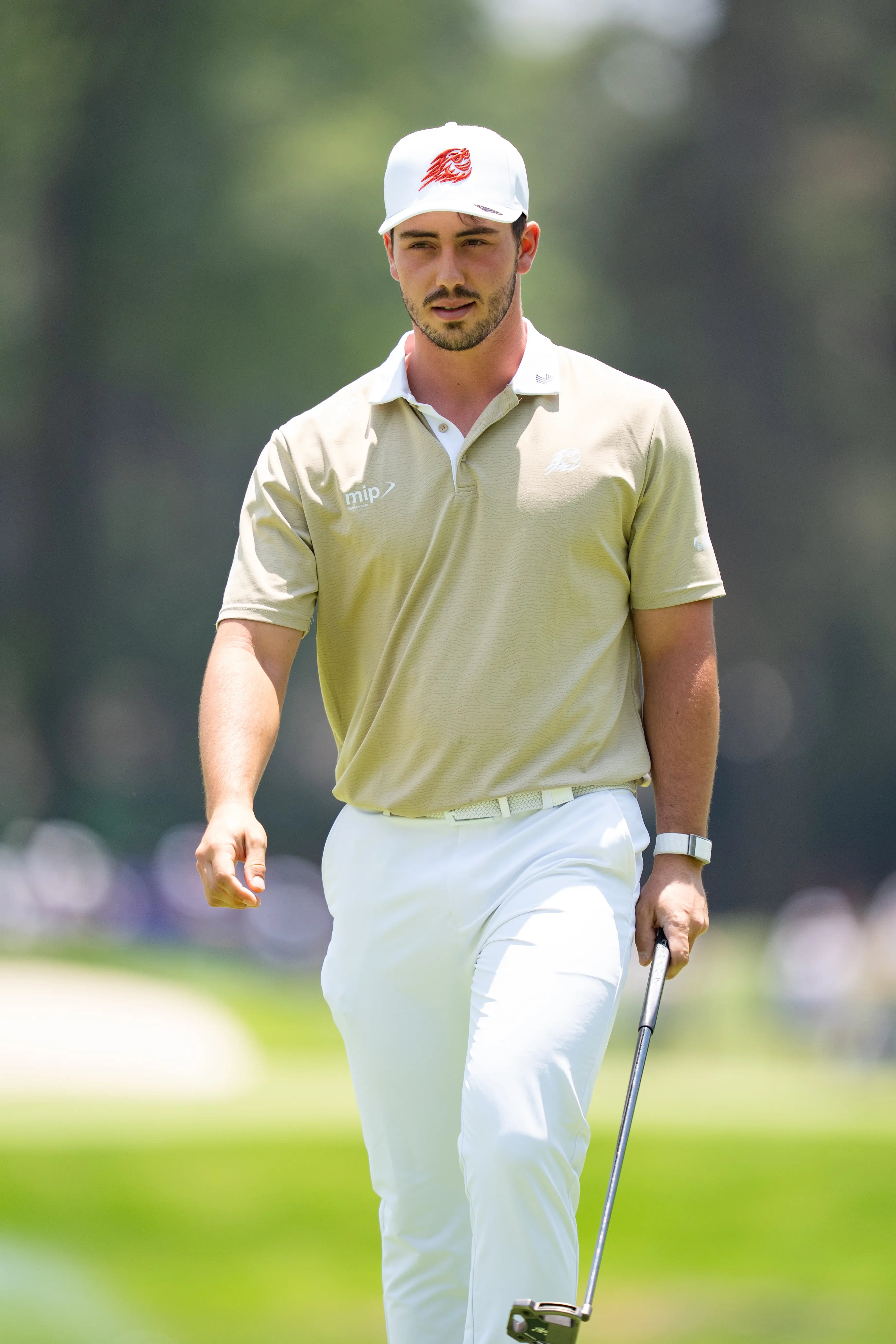 Tour player walking between shots in Stuburt tan trousers
